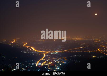 Vue nocturne des routes sinueuses dans le paysage urbain vu depuis la montagne Xiangshan, à Pékin, par une nuit de pleine lune Banque D'Images