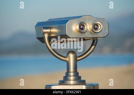 Binoculaire Public sur mer, Close up. Jumelles à monnayeur viewer sur fond flou de coucher du soleil et de la mer. Batumi, Géorgie Banque D'Images