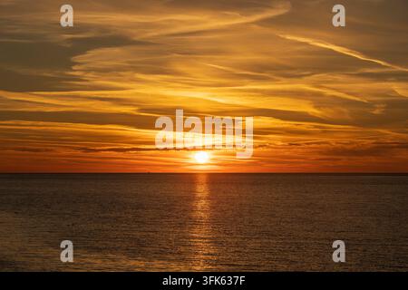 Vue majestueuse sur un coucher de soleil avec une surface d'eau de mer. Coucher de soleil ciel avec nuages et eau de mer Banque D'Images