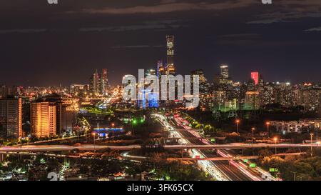 Scène nocturne de Pékin, paysage urbain vibrant avec un viaduc et la tour CITIC entrelacés dans des lumières éblouissantes Banque D'Images