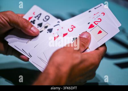 Vue d'une personne tenant un éventail de cartes à jouer lors d'une partie à Estoril, Lisboa, Portugal. Banque D'Images