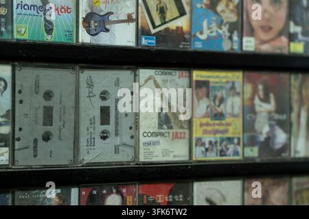 Des cassettes vintage et une pochette d'album de jazz bordent une étagère en bois poussiéreuse de collectibles musicaux rétro à Chiang Mai, Thaïlande Banque D'Images