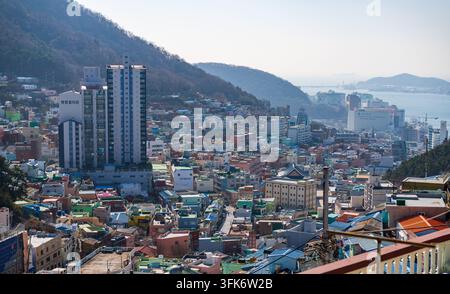Busan, Corée du Sud - 14 février 2026 : Vue du village culturel de Gamcheon avec des maisons colorées, des rues étroites et des immeubles modernes en hauteur nichés Banque D'Images