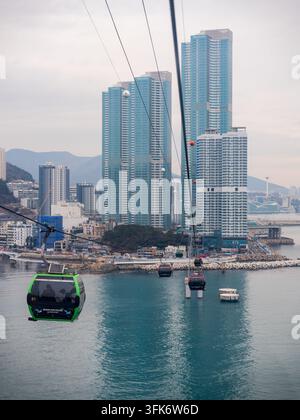 Busan, Corée du Sud - 14 février 2026 : Vue de la téléphérique de Songdo planant au-dessus de la mer avec des immeubles modernes en arrière-plan. Banque D'Images