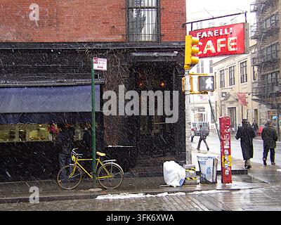 New York, États-Unis - 28 février 2005 : Vue du Fanelli Cafe avec un vélo jaune garé sur le trottoir lors d'une journée enneigée à New York. Banque D'Images