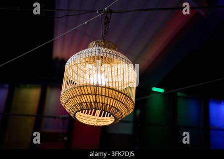 Close up d'une lampe suspendue en osier tressé suspendue à l'intérieur, à Koh Samui, Thaïlande, le 24 février 2025 Banque D'Images
