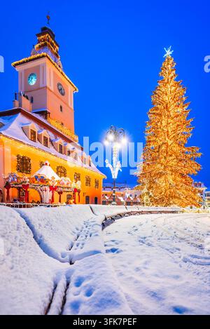 Scène enneigée du marché de Noël de Brasov, de la maison du conseil et de l'énorme sapin de Noël. Banque D'Images