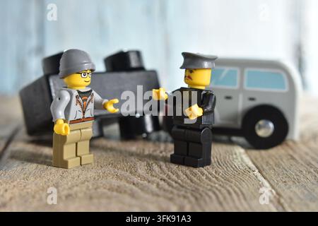Jouet Lego policier inspectant une voiture pour des dommages après un accident Banque D'Images