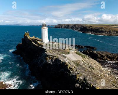 Paysage panoramique aérien du phare de Godrevy sur l'île de Godrevy dans la baie de St Ives en Cornouailles, Royaume-Uni, par une belle journée ensoleillée avec des vagues blanches s'écrasant o Banque D'Images