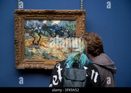Deux jeunes visiteurs contemplant « Arbres oliviers (1889) » de Vincent Van Gogh à la Scottish National Gallery, Édimbourg, Écosse, Royaume-Uni. Banque D'Images