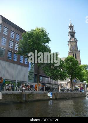 AMSTERDAM - 23 MAI 2025 - Canal historique d'Amsterdam avec clocher de la Zuiderkerk, vélos traditionnels le long du front de mer, paysages urbains néerlandais classiques Banque D'Images