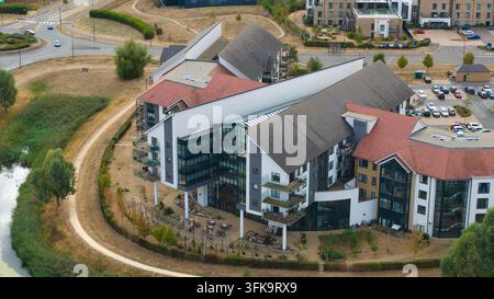 Vue aérienne du Wixams Retirement Village présentant une architecture moderne avec des toits inclinés et des façades en verre, entouré de terrains paysagers et d'un Po Banque D'Images