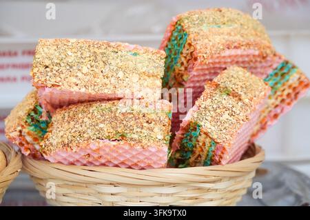Gâteau gaufré dans un panier en osier sur un étal de marché. Dessert. Nourriture de rue Banque D'Images