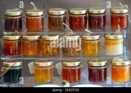 Variété de confitures dans des bocaux exposés sur un étal de marché Banque D'Images