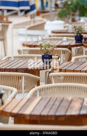 Tables et chaises d'extérieur élégantes dans un complexe hôtelier de luxe. Espace de restauration extérieur stylé dans un complexe hôtelier moderne avec des tables en bois Banque D'Images
