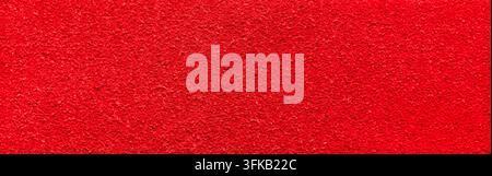 Un plan macro en gros plan d'un matériau en daim rouge vif ou d'un velours fibrous mettant en valeur une texture douce et veloutée. La surface cramoisie intense présente Banque D'Images