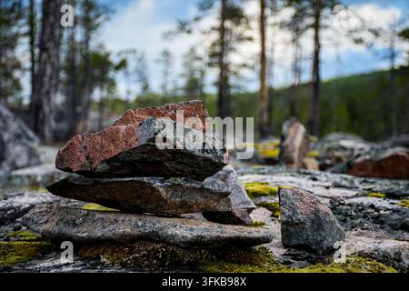Pierres empilées sur un sol rocheux dans la forêt de Granudden dans la municipalité de Jokkmokk, dans le nord de la Suède. Banque D'Images