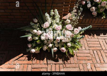 Vue de dessus d'un bouquet de roses roses sur un sol en briques rouges Banque D'Images
