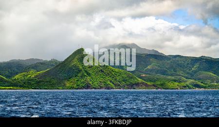 Collines et montagnes volcaniques d’un vert luxuriant s’élevant de l’océan bleu le long de la côte pittoresque de Dominique dans les Caraïbes Banque D'Images