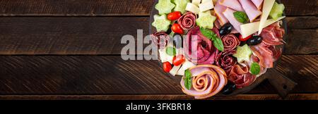 Planches et boîtes de charcuterie colorées avec légumes, viande et fromage. Assortiment de délicieuses entrées ou antipasti. Vue de dessus. Bannière Banque D'Images