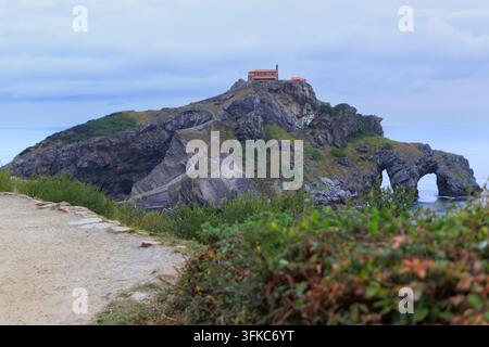 L'îlot de San Juan de Gaztelugatxe mettant en valeur l'antique ermitage perchée sur son sommet, reliée par un escalier de pierre ascendant, avec des falaises escarpées et Banque D'Images