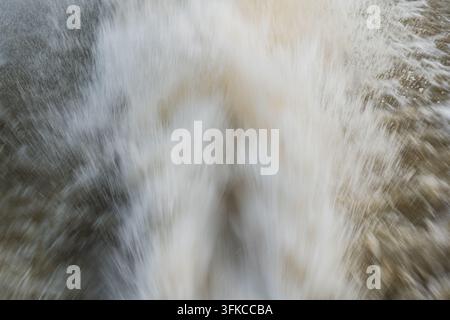 Prise de vue rapprochée détaillée capturant les éclaboussures d'eau blanche en mouvement rapide, la flou de mouvement et l'eau moussante tourbillonnante générée par un moteur de bateau se déplaçant rapidement Banque D'Images