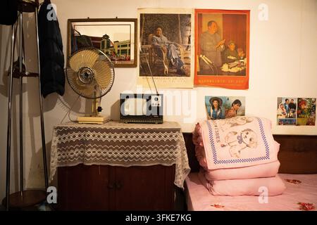 Ventilateur vintage et vieux téléviseur noir et blanc sur le mur dans une pièce de style rétro Banque D'Images