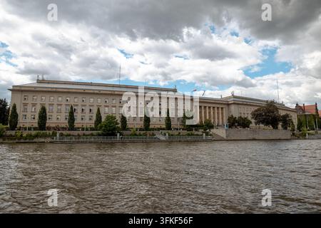 Le bureau de la voïvodie de Basse-Silésie s'étend le long de la berge de l'Oder sous des nuages dramatiques. Banque D'Images