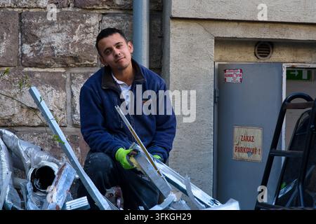 Photo éditoriale d'un homme au travail avec des matériaux de construction en plein air, Slovaquie, 18 mars 2026. Banque D'Images
