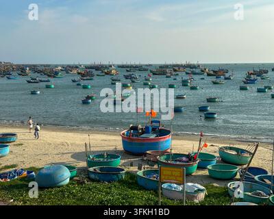 Bateaux traditionnels ronds en panier sur une plage de sable au bord de la mer. De nombreux bateaux traditionnels ronds en panier et des bateaux de pêche colorés reposant sur un sable Banque D'Images
