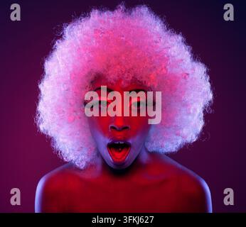 Femme afro blanche l'air choqué avec fond violet. Banque D'Images