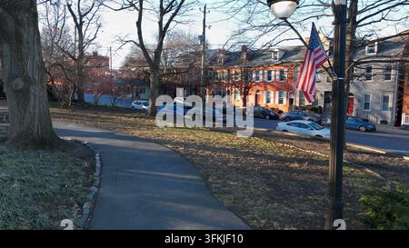Vue aérienne du drapeau américain flottant par une froide journée d'hiver dans un parc à côté des logements urbains de Lancaster, Pennsylvanie. Banque D'Images