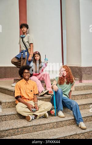 Portrait d'adolescents multiethniques traînant à l'extérieur sur des marches Banque D'Images