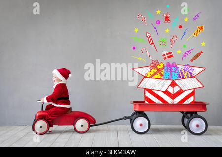 Enfant heureux payant à la maison. Enfant s'amusant pendant la période de Noël. Concept de vacances de Noël Banque D'Images