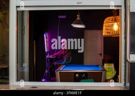 Homme jouant à une machine à sous dans un salon de jeux Banque D'Images