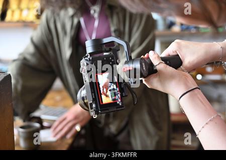 Photographe, vidéaste utilisant une Steadicam tenue à la main pendant le tournage des mains floues d'une femme Banque D'Images