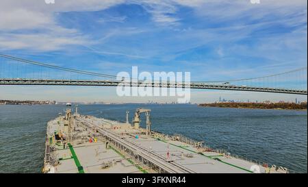 Vue du pont d'un pétrolier naviguant sous le pont de Verrazzano-Narrows en direction de la ligne d'horizon de New York dans la baie de l'Hudson par une journée ensoleillée Banque D'Images