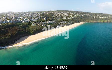 Un paysage panoramique aérien de la destination touristique populaire de Carbis Bay avec sa belle plage de sable blanc près de St Ives dans les Cornouailles, Royaume-Uni avec Banque D'Images