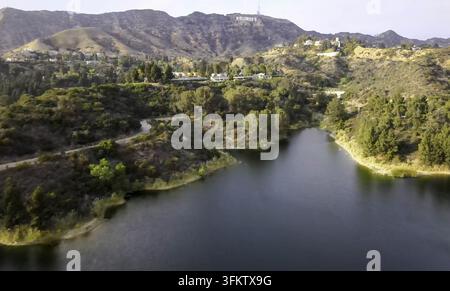 Vue aérienne du réservoir de Hollywood avec le panneau emblématique de Hollywood visible sur les collines en arrière-plan, entouré d'une végétation luxuriante et d'arbres en Banque D'Images