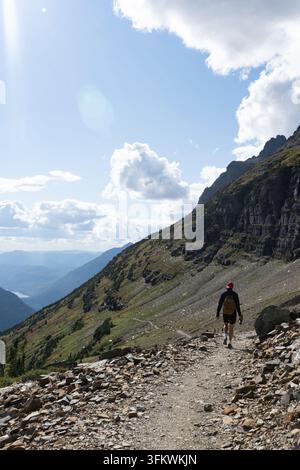 Randonneur sur le sentier Highline en dessous d'une crête rocheuse. Un promeneur suit un étroit sentier creusé sous une falaise. Banque D'Images
