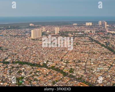 Une vue aérienne époustouflante capture un paysage urbain étendu avec un horizon côtier, mettant en valeur les bâtiments de Surabaya Banque D'Images