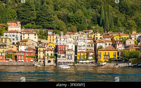 Maisons historiques colorées le long du front de mer de Varenna nichées sous des collines verdoyantes sur le lac de Côme, Varenna, Lombardie, Italie Banque D'Images