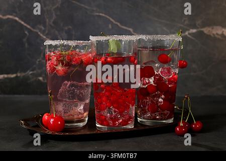 Eau diététique vegane avec framboises, groseilles et cerises, eau détox, mojito avec Sprite, menthe et baies fraîches. Concept de régime détox et de perte de poids Banque D'Images