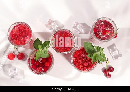 Eau diététique vegane avec framboises, groseilles et cerises, eau détox, mojito avec Sprite, menthe et baies fraîches. Concept de régime détox et de perte de poids Banque D'Images