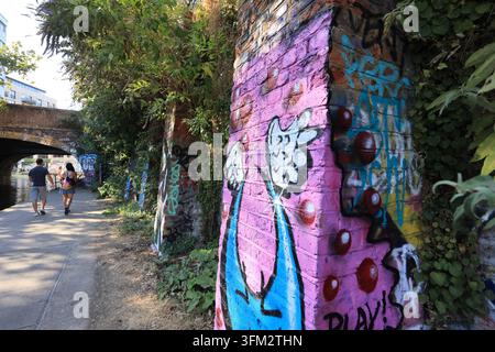 Art graffiti le long du chemin de halage du Regents Canal entre Camden Town et Kings Cross, au nord de Londres, Royaume-Uni. Banque D'Images