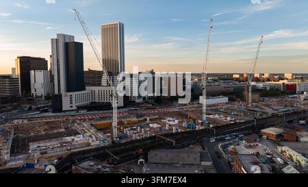 Vue aérienne du chantier de construction de la gare HS2 de Curzon Street à Birmingham au soir, montrant plusieurs grues, la voie ferrée existante et le développement urbain Banque D'Images