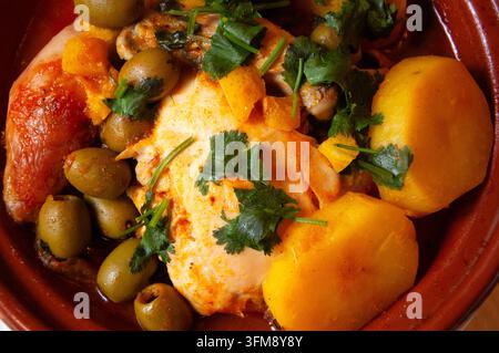 Tajine de poulet marocaine avec citron, olives vertes, pommes de terre et persil frais sur une assiette en céramique, cuisine traditionnelle maison nord-africaine Banque D'Images