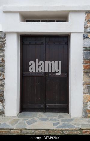 Porte double en bois sombre dans une façade en pierre blanche Banque D'Images
