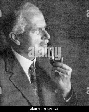 Une photographie de Carl Gustav Jung (1875–1961), le psychiatre et psychanalyste suisse qui a fondé la psychologie analytique. Après sa collaboration précoce avec Sigmund Freud, Jung a développé ses propres théories influentes concernant la psyché humaine, y compris les concepts de l'inconscient collectif, de la synchronicité et des figures archétypales. Il est représenté ici de profil, portant un costume et des lunettes sans monture tout en tenant une pipe à tabac. C. 1935. Banque D'Images