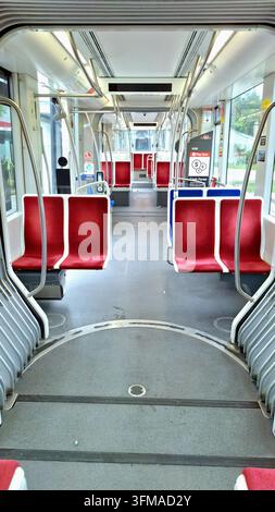 Toronto, ON, Canada – 25 septembre 2026 : La vue intérieure d’un tramway public moderne et vide montrant des sièges rouges et un couloir. Banque D'Images